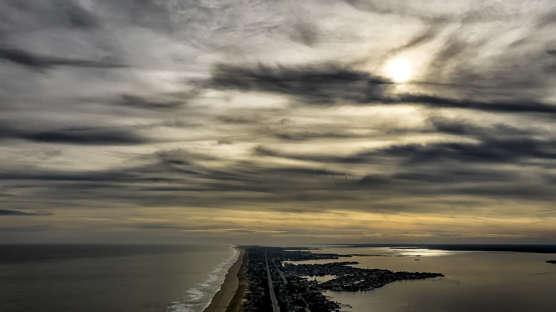 Aerial view of Mantoloking, NJ — a narrow barrier-island strip of oceanfront and bayfront luxury homes between the Atlantic Ocean and Barnegat Bay